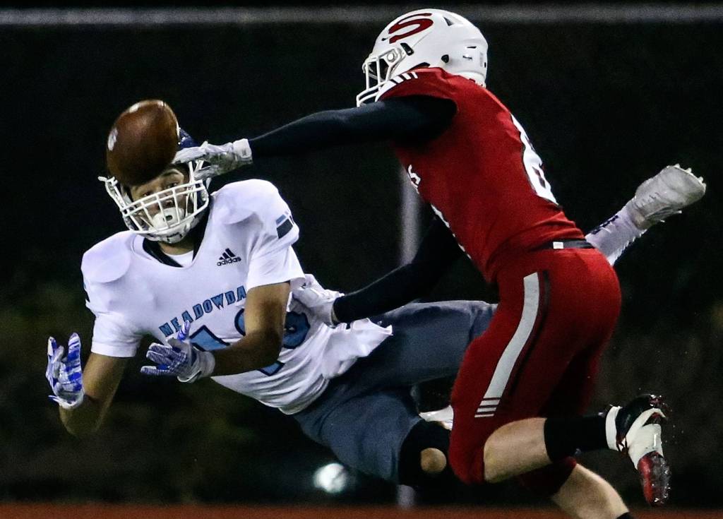 Meadowdales Colton Walsh attempts a catch with Snohomishs Hunter Philabaum trailing Friday evening at Veterans Memorial Stadium in Snohomish on October 25, 2019. (Kevin Clark / The Herald)