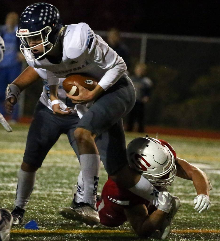 Meadowdales Hunter Moen is tackles by Snohomishs Tyler Larson Friday evening at Veterans Memorial Stadium in Snohomish on October 25, 2019. (Kevin Clark / The Herald)