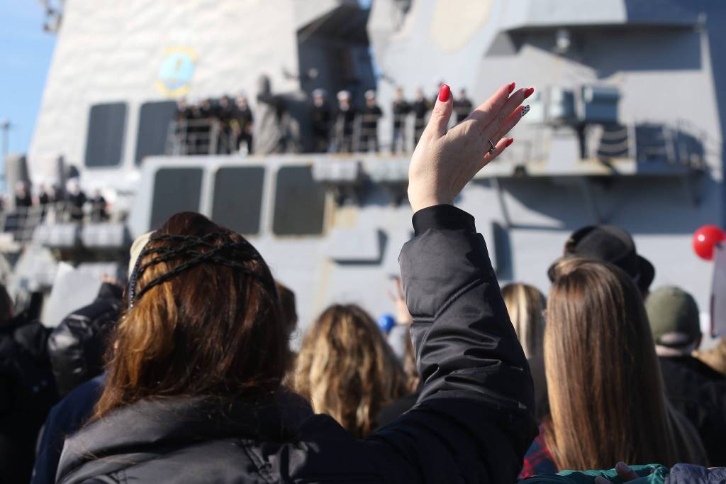 Families and friends wait to greet sailors from the USS Momsen (DDG-92) as it returns to Naval Station Everett after a deployment to the Pacific on Monday in Everett. (Andy Bronson / The Herald)