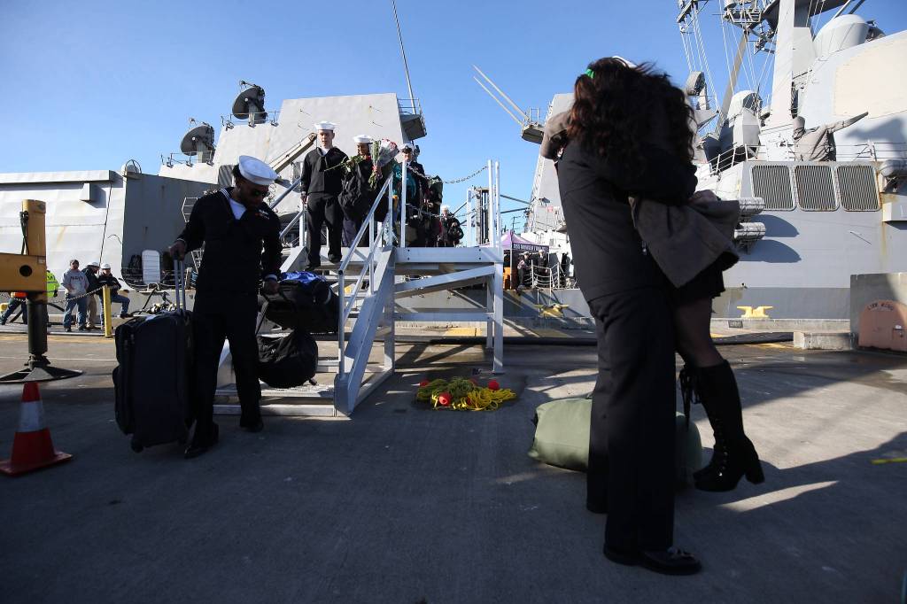 Families and friends wait to greet sailors from the USS Momsen (DDG-92) as it returns to Naval Station Everett after a deployment to the Pacific on Monday in Everett. (Andy Bronson / The Herald)