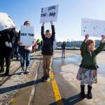 Holland Piram (right) holds her sign upside down as she, her brother Roman, and mother, Sophie, wait for Tom Piram to arrive aboard the USS Momsen (DDG-92) as it returns to Naval Station Everett after a deployment to the Pacific on Monday in Everett. (Andy Bronson / The Herald)