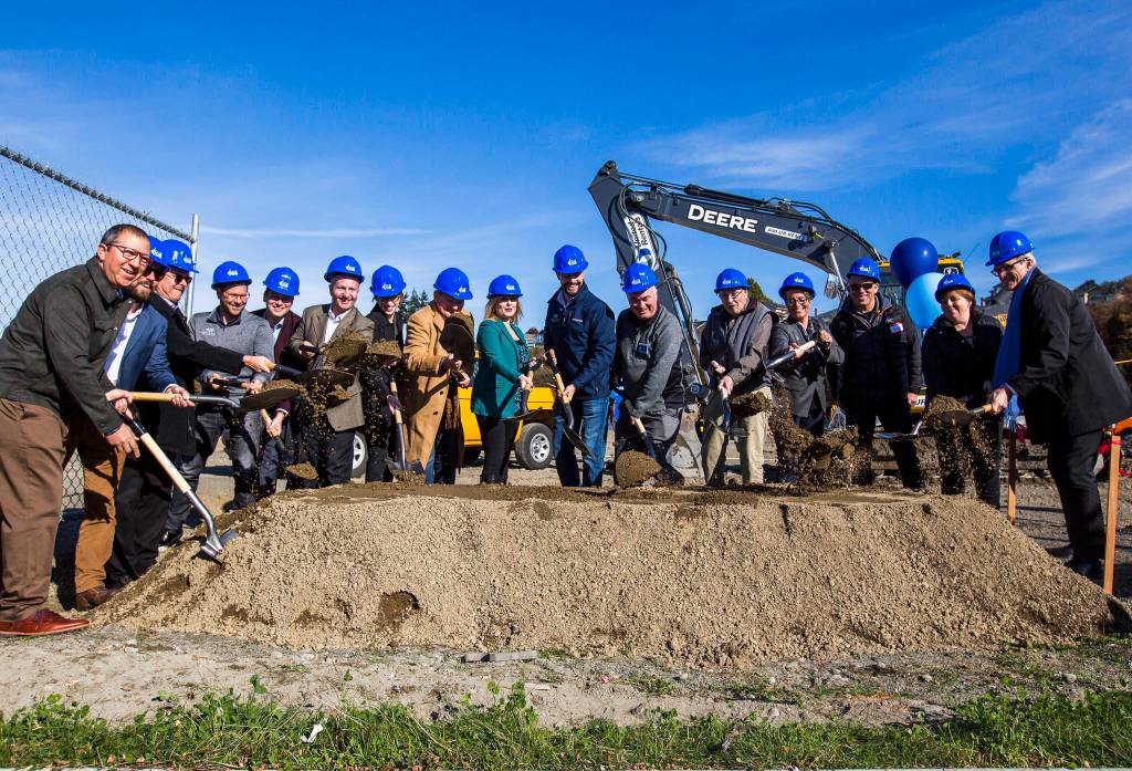 Everett officials along with contractors and construction company members break ground at the Waterfront Place Apartments along the Everett waterfront Wednesday. (Olivia Vanni / The Herald)