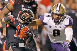 Washington linebacker Benning Potoae (8) tackles Utah wide receiver Britain Covey, left, in the first half during an NCAA college football game Saturday, Sept. 15, 2018, in Salt Lake City. (AP Photo/Rick Bowmer)