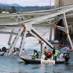A boat crew examines a upside down car in the Skagit River after the I-5 bridge collapsed in May 2013. (Jennifer Buchanan / Herald file)