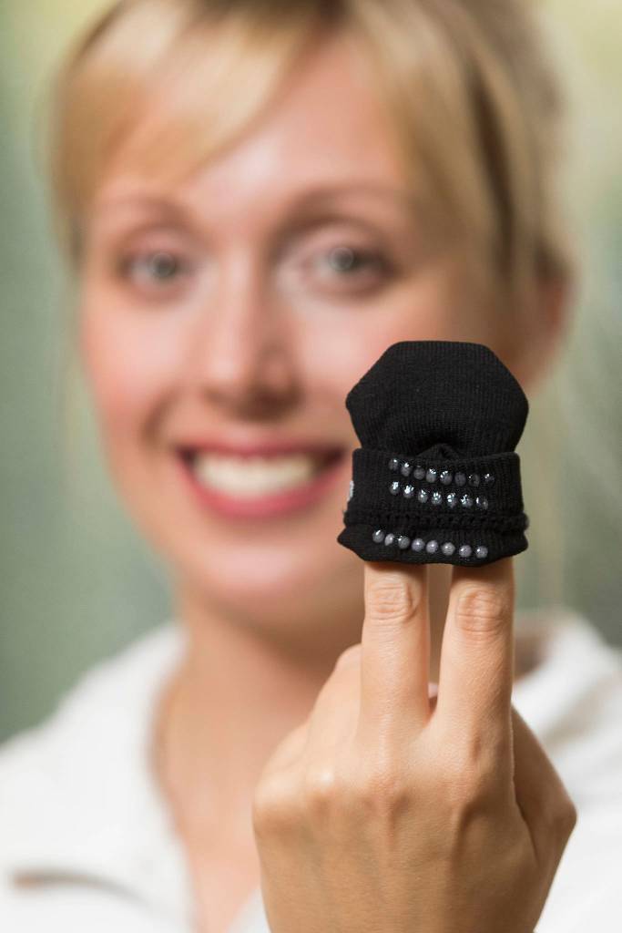 Jessica Miller, co-owner of Squid Socks, shows off the silicone dots that keep them from slipping from the feet of toddlers. (Andy Bronson / The Herald)