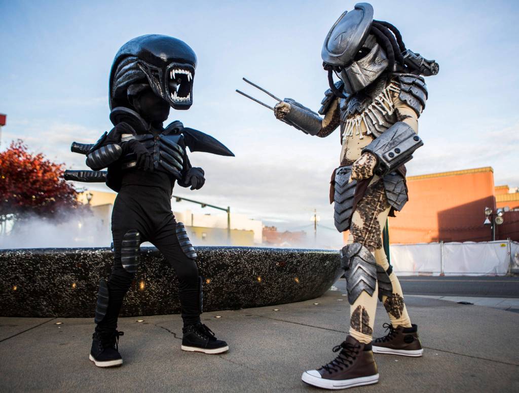 Gavin Brown, 8, dressed as Alien, and Kaleb Brown, 11, dressed as Predator, went trick-or-treating in costumes made by their dad during downtown trick-or-treating Thursday in Everett. (Olivia Vanni / The Herald)