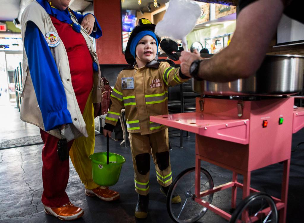 Desmond Smith, 5, gets a cotton candy from Eight Ball Cafe during Downtown Trick-or-Treating on Oct. 31, 2019 in Everett, Wash. (Olivia Vanni / The Herald)