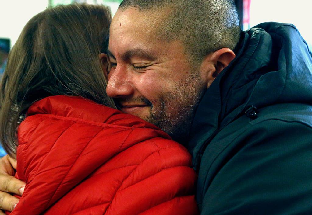 Fernando Moratalla, a U.S. Marine veteran, hugs Myra Rintamaki at the Veterans Resource Center at Edmonds Community College Tuesday. Rintamaki is a Gold Star Mother whose Marine Corps son Steven was killed in Iraq in 2004. Moratalla is an immigrant from Venezuela. (Dan Bates / The Herald)