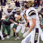 Senior running back Daniel Tran runs through the Marysville Getchell defense on Friday, Nov. 1 at Quil Ceda Stadium in Marysville. (Katie Webber / The Herald)