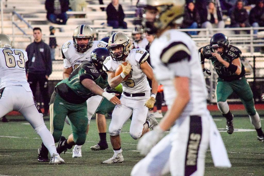 Senior running back Daniel Tran runs through the Marysville Getchell defense on Friday, Nov. 1 at Quil Ceda Stadium in Marysville. (Katie Webber / The Herald)