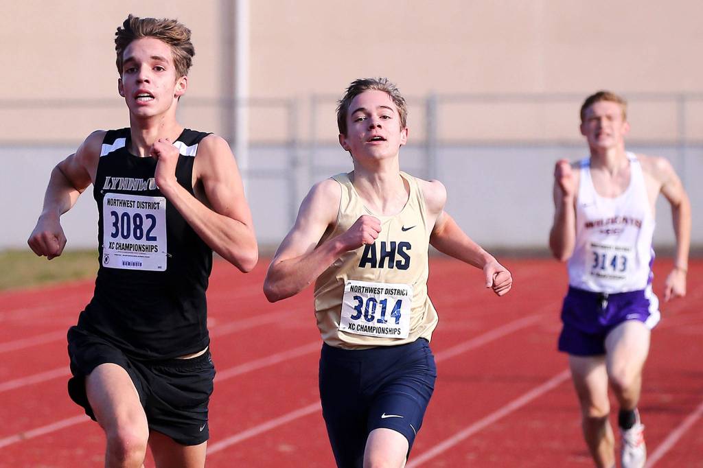 Lynnwoods Micah Murphy (left) and Arlingtons Vincent Loftis race for the finish Saturday during the District 1 Cross Country Championship at South Whidbey High School in Langley on Saturday. (Kevin Clark / The Herald)
