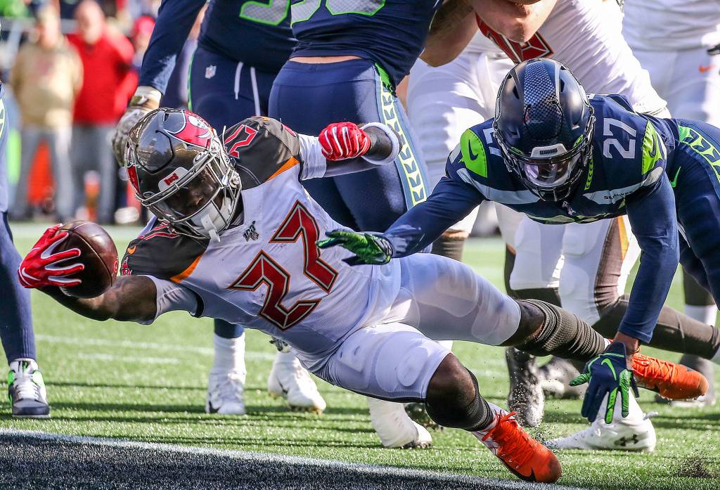 Buccaneers Ronald Jones II stretches a touchdown against the Seahawks Marquise Blair Sunday afternoon at CenturyLink Field in Seattle on November 3, 2019. (Kevin Clark / The Herald)
