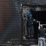 Fire investigators, right, talk as firefighters remove debris after a fatal fire at 6707 196th St. SW on Monday, Nov. 4, 2019 in Lynnwood, Wash. (Andy Bronson / The Herald)