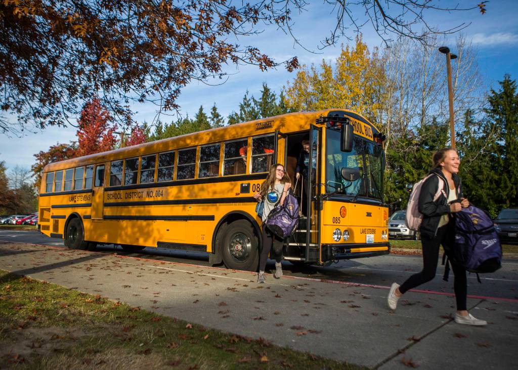 The Lake Stevens swim team gets off their bus for swim practice at Explorer Middle School on Nov. 6, 2019 in Everett, Wash. (Olivia Vanni / The Herald)