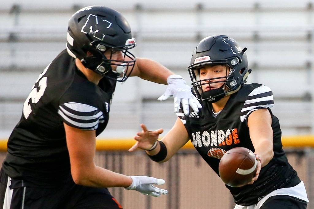 Gio Fregoso (right) hands off to Blake Rybar during practice Wednesday evening at Monroe High School on November 6, 2019.(Kevin Clark / The Herald)