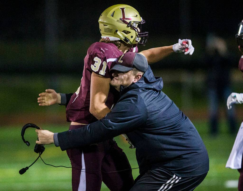 Lakewoods Riley Krueger is picked up by a coach as they celebrate on the sidelines during a 2A playoff game against Liberty on Nov. 8, 2019 in Arlington, Wash. (Olivia Vanni / The Herald)