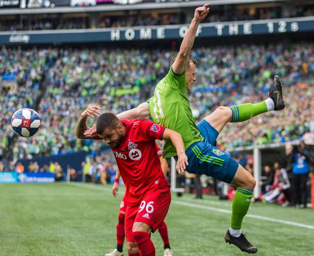 Sounders defender Brad Smith and Toronto defender Auro Jr. jump for the ball during the MLS Cup on Nov. 10, 2019 in Seattle, Wash. (Olivia Vanni / The Herald)