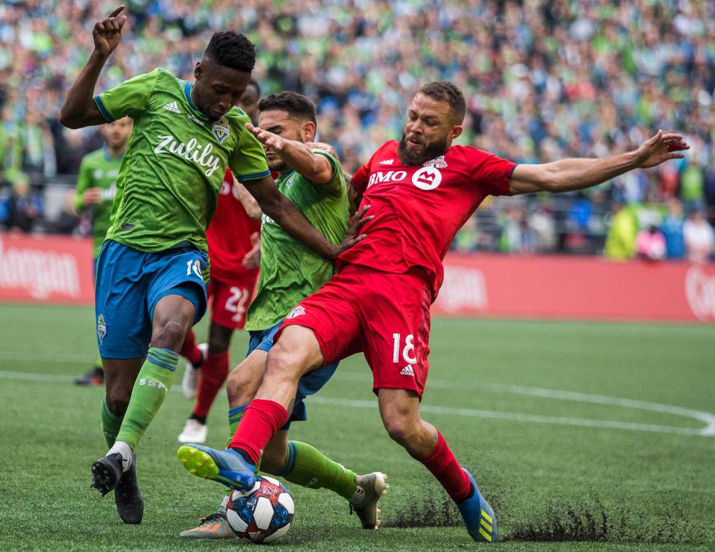 Sounders defender Kelvin Leerdam and Sounders midfielder Cristian Roldan fight Toronto midfielder Nick DeLeon for the ball during the MLS Cup on Nov. 10, 2019 in Seattle, Wash. (Olivia Vanni / The Herald)