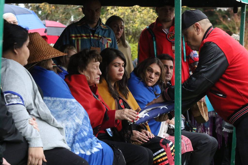 JoAnn Jones accepts an American flag from a member of the Tulalip Tribes Honor Guard during the funeral for her husband Stan Jones Sr., the Tulalip Tribes longest serving board member and chairman, at Mission Beach Cemetery on Tuesday. (Andy Bronson / The Herald)