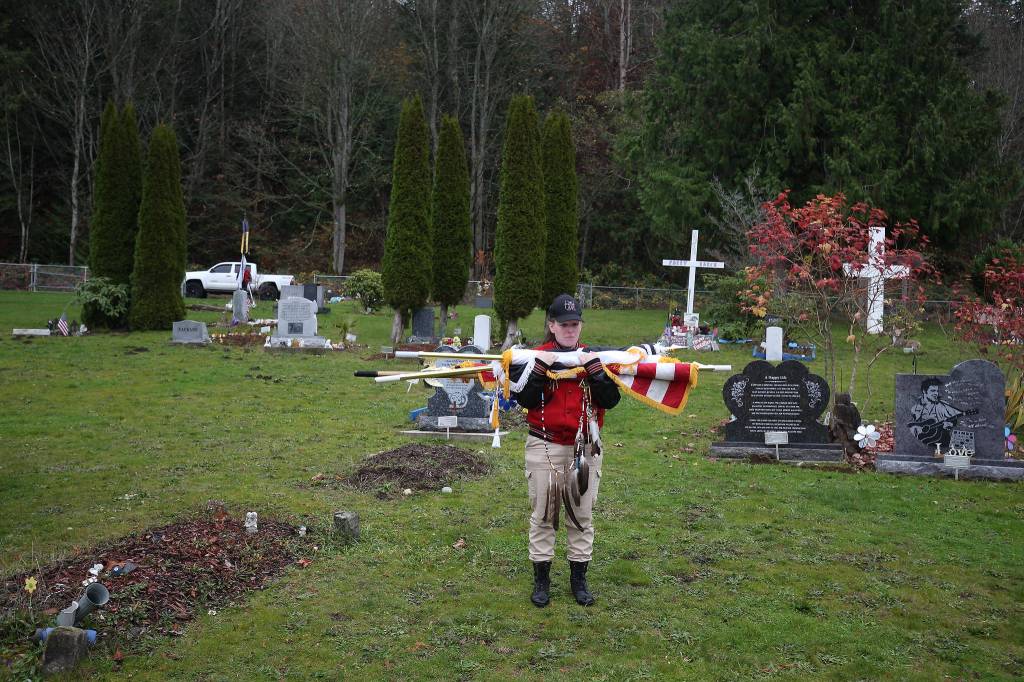 At Mission Beach Cemetery, a member of the Tulalip Tribes Honor Guard holds flags before the funeral for Stan Jones Sr., the Tulalip Tribes longest-serving board member and chairman, on Tuesday. (Andy Bronson / The Herald)