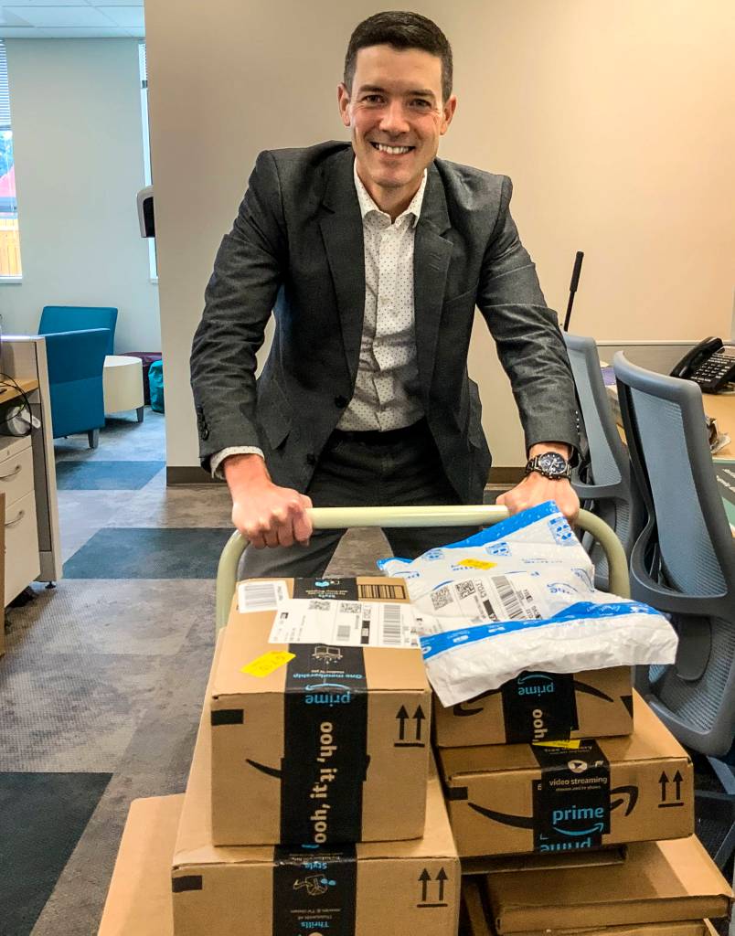Joseph Alonzo, CEO of Cocoon House, moves a cartload of books arriving from Amazon.