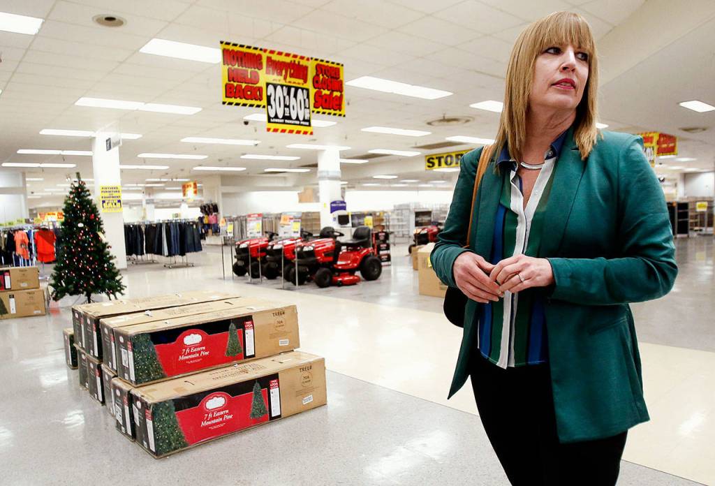 Doreen Ricci walks around the Everett Sears store Wednesday where her late father, Jake Boersema, worked for decades. The big store appears oddly spacious with clusters of Christmas trees, riding lawnmowers and other bargains on a sea of linoleum. (Dan Bates / The Herald)