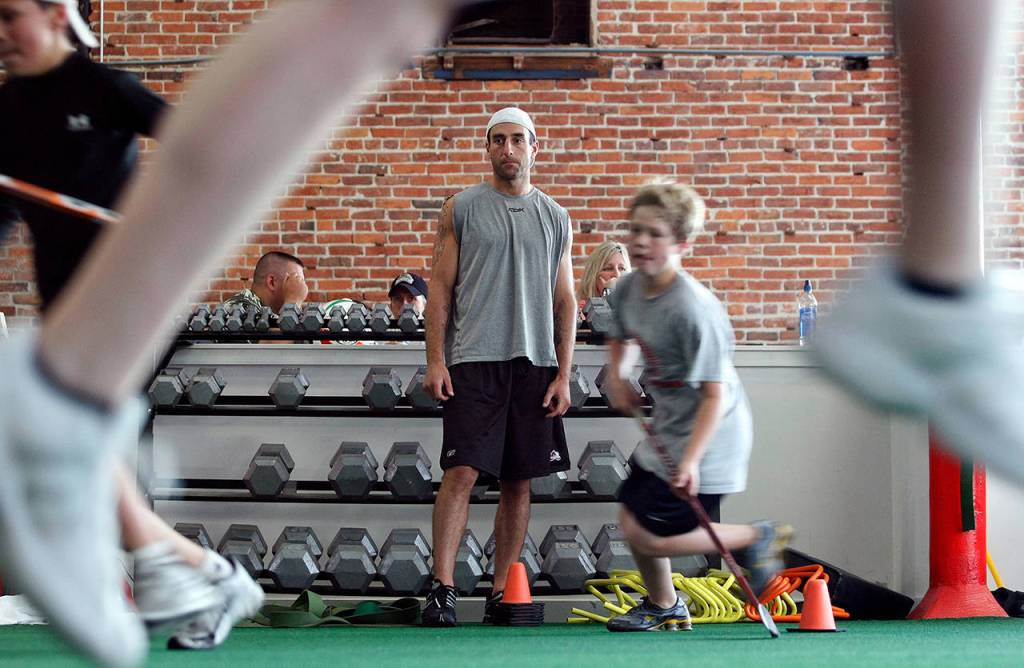 Former Everett Silvertip Mitch Love watches youngsters take part in an agility drill during one of summer camps he put on in Everett. (Jennifer Buchanan / Herald file)