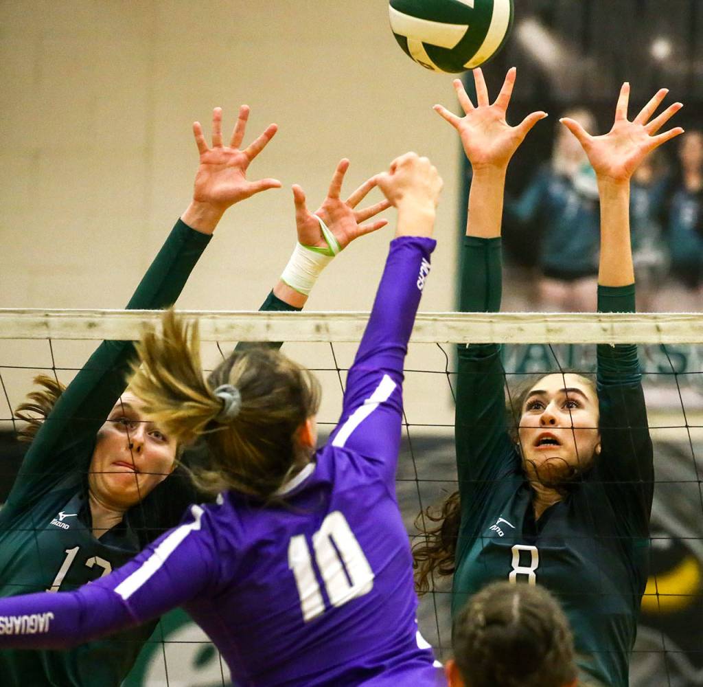 Jacksons Ainsley Johanson (left) and Erin Ingram attempt a block on North Creeks Allison Wilks. (Kevin Clark / The Herald)