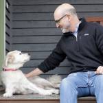 University of Washington School of Medicine researcher Daniel Promislow, the principal investigator of the Dog Aging Project grant, sits with his elderly dog Frisbee at their home in Seattle. (AP Photo/Elaine Thompson)