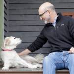 Elaine Thompson / Associated Press                                University of Washington School of Medicine researcher Daniel Promislow, the principal investigator of the Dog Aging Project grant, sits with his elderly dog Frisbee at their home in Seattle. (AP Photo/Elaine Thompson)