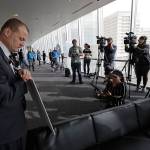 Anti-tax activist Tim Eyman leans on a sign as he prepares to talk to reporters, Nov. 7, outside the office of Seattle Mayor Jenny Durkan in Seattle. (Ted S. Warren / Associated Press)