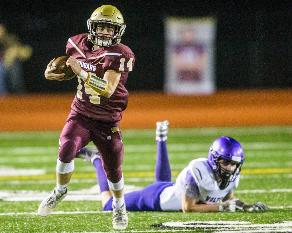 Lakewoods Mason Toponce escapes the tackle of a Sequim defender and runs down the field during a 2A state playoff game on Friday in Arlington. (Olivia Vanni / The Herald)