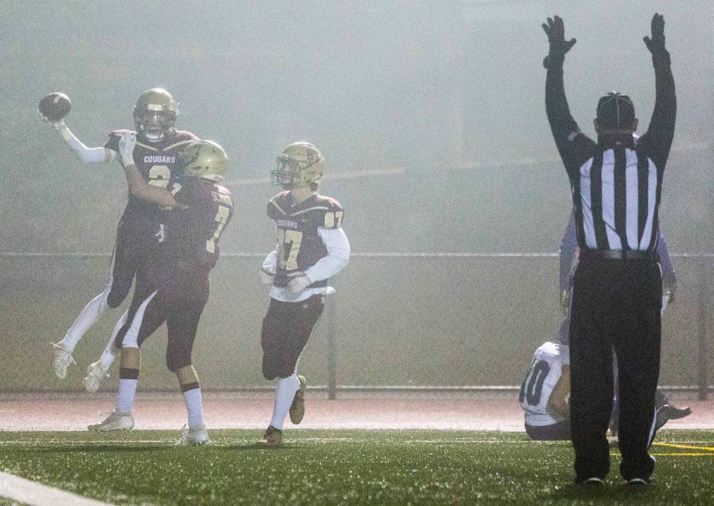 Lakewoods Carson Chrisman (with football) celebrates with teammates Jackson Schultz (7) and Hayden Richardson (97) after scoring a touchdown during a 2A state playoff game on Friday in Arlington. (Olivia Vanni / The Herald)