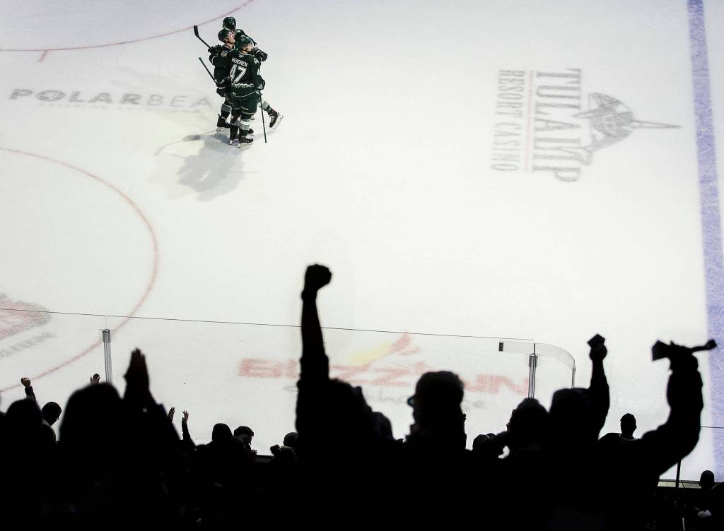 Silvertips Parker Hendren and Max Patterson congratulate Gianni Fairbrother on his goal as the crowd cheers during the game against the Spokane Chiefs on Nov. 17, 2019 in Everett, Wash. (Olivia Vanni / The Herald)