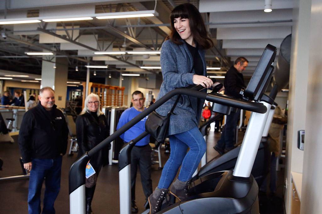 Danielle Pratt tries out new stair-climbing equipment on saturday at the new Everett YMCA. (Kevin Clark / The Herald)