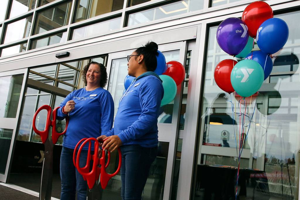With scissors ready, Lauren Cahill (left) and Donny Willeto await the ribbon cutting ceremony Saturday morning. (Kevin Clark / The Herald)