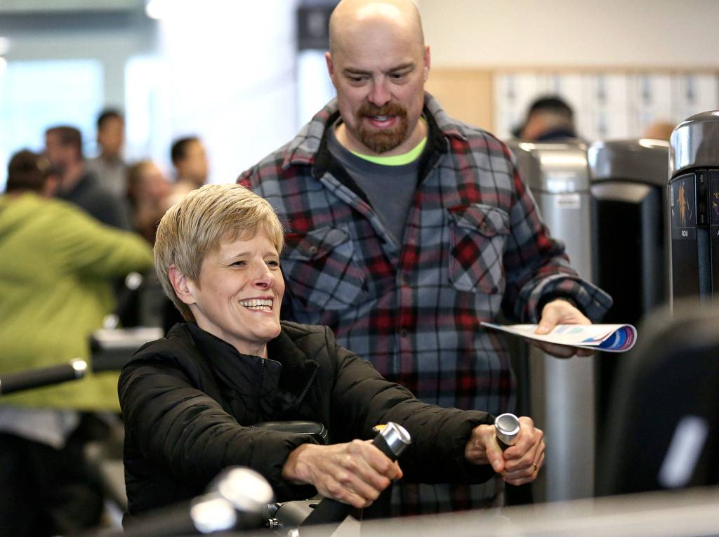 Diane Zaugg tries out exercise equipment with husband Reid Zaugg in the soon-to-be opened Everett YMCA. (Kevin Clark / The Herald)