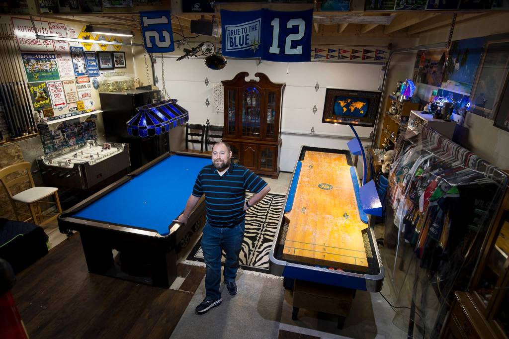 Josh Whall in his gaming room, the garage, at his home on Nov. 22 in Marysville. The room has shuffleboard, hockey table and a pool table, and even a collection of the patches from each of the MLBs All-Star games. (Andy Bronson / The Herald)