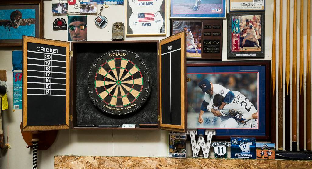 Pictures of Baseball Hall of Fame pitcher Nolan Ryan and swimming memorabilia surround a dartboard made by Josh Whalls father. (Andy Bronson / The Herald)