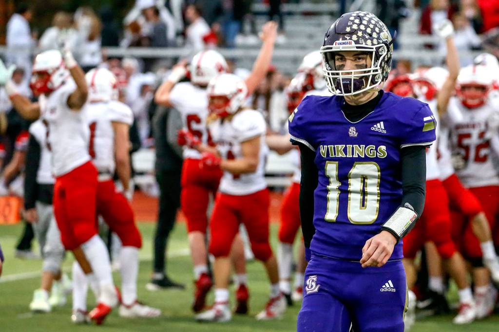 Lake Stevens quarterback Tanner Jellison walks of the field as Mount Si players celebrate after the Wildcats beat the Vikings 24-22 in a 4A state quarterfinal game on Saturday afternoon at Lake Stevens High School. (Kevin Clark / The Herald)