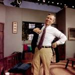 Fred Rogers puts on his jacket between takes on the set of his television program Mister Rogers Neighborhood in Pittsburgh on June 8, 1993. (Gene J. Puskar / Associated Press file photo)