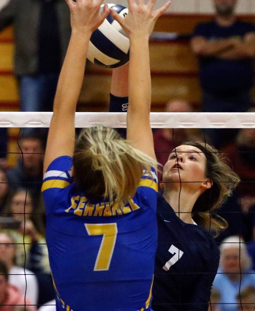 Arlingtons Arianna Bilby (right) attempts a kill over Ferndales Malia Honrud on Nov. 14 at Marysville-Pilchuck High School. (Kevin Clark / The Herald)