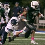 Shorecrests Markus Selzler avoids a tackle by Meadowdales Mason Vaughn during a game Friday night at Shoreline Stadium. (Kevin Clark / The Herald)