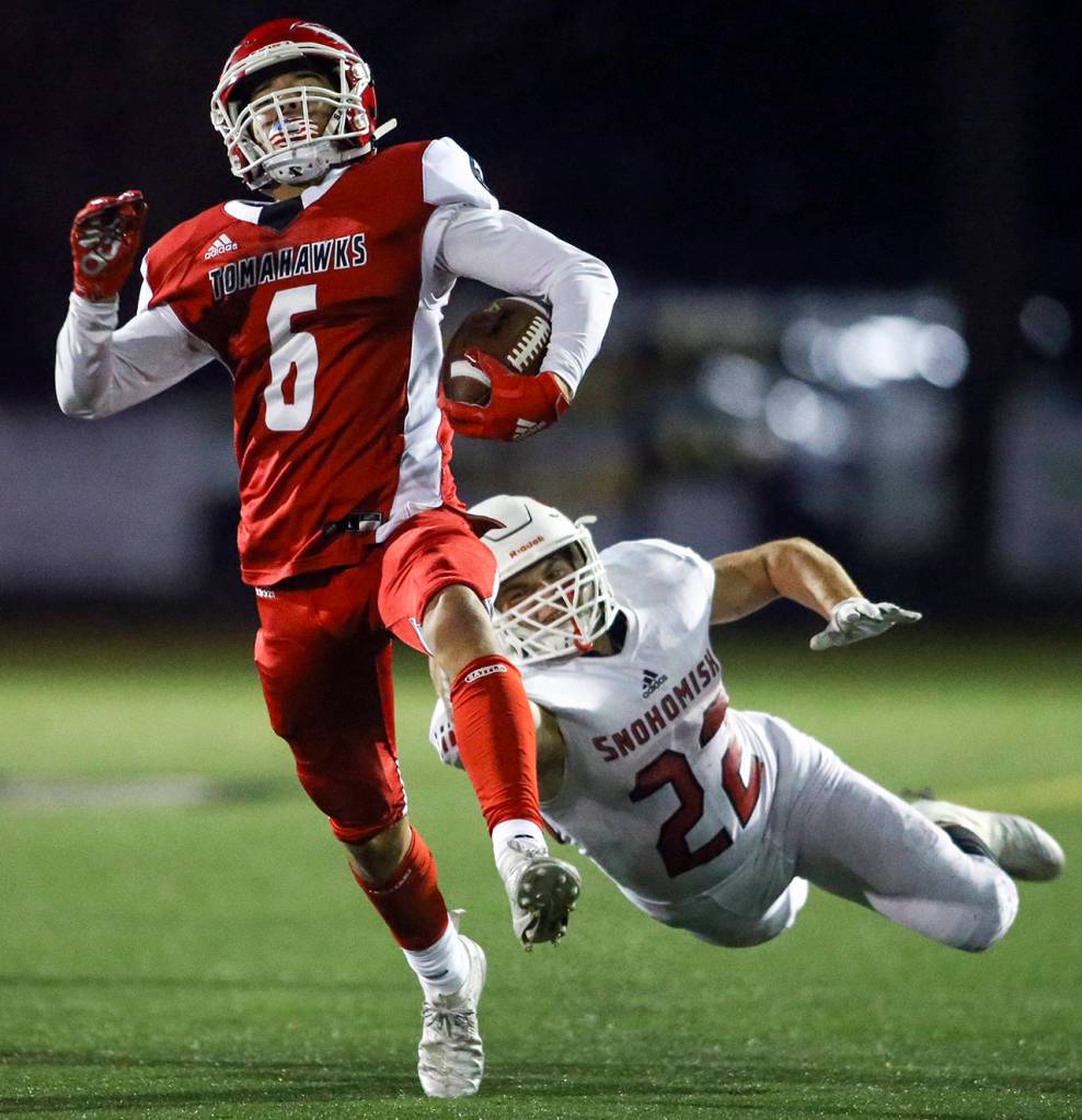 Marysville-Pilchucks Dillon Kuk high steps to avoid a tackle by Snohomishs Tyler Larson during the Wesco 3A Championship Friday evening at Quil Ceda Stadium on November 1, 2019. Marysville-Pilchuck led 35-3 at halftime. (Kevin Clark / The Herald)