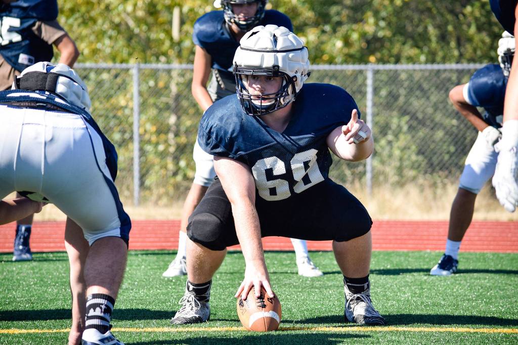 Senior Tony McDaniel gets set to hike the ball during lineman drills at Glacier Peak High School on Tuesday, Aug. 27. (Katie Webber / The Herald)