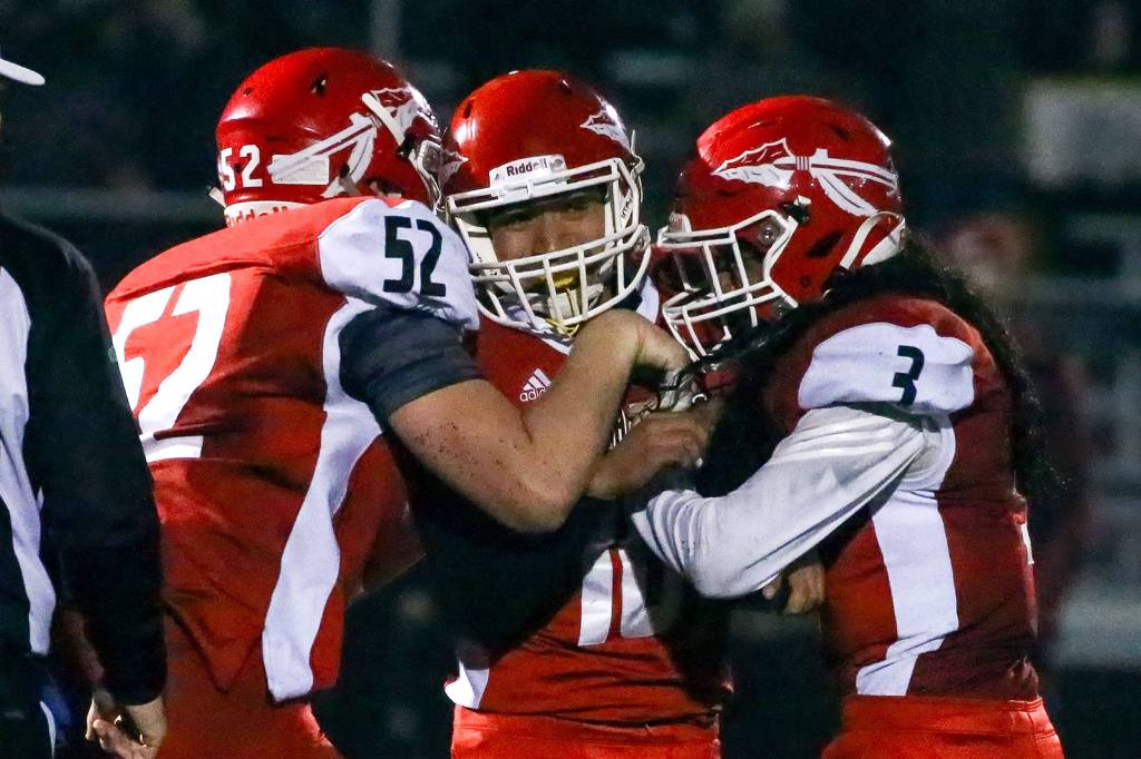 Marysville-Pilchucks Nate Elwood (left) and Zion Botelho (right) celebrates Edgar Martinez (center) game tying field goal to force overtime against Prairie Friday evening at Quil Ceda Stadium in Marysville on November 15, 2019. Marysville-Pilchuck won 37-30 in overtime. (Kevin Clark / The Herald)