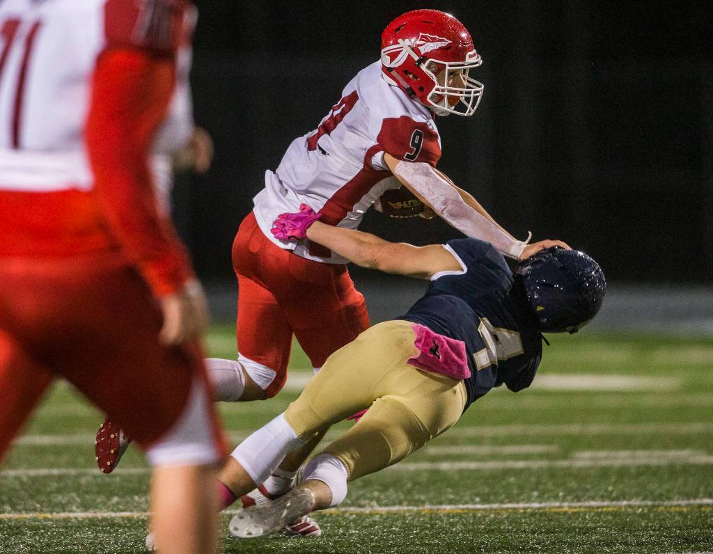 Marysville-Pilchuck’s Jordan Justice pushes Arlington’s Joseph Schmidt to the ground during the game on Oct. 25, 2019 in Arlington, Wash. (Olivia Vanni / The Herald)