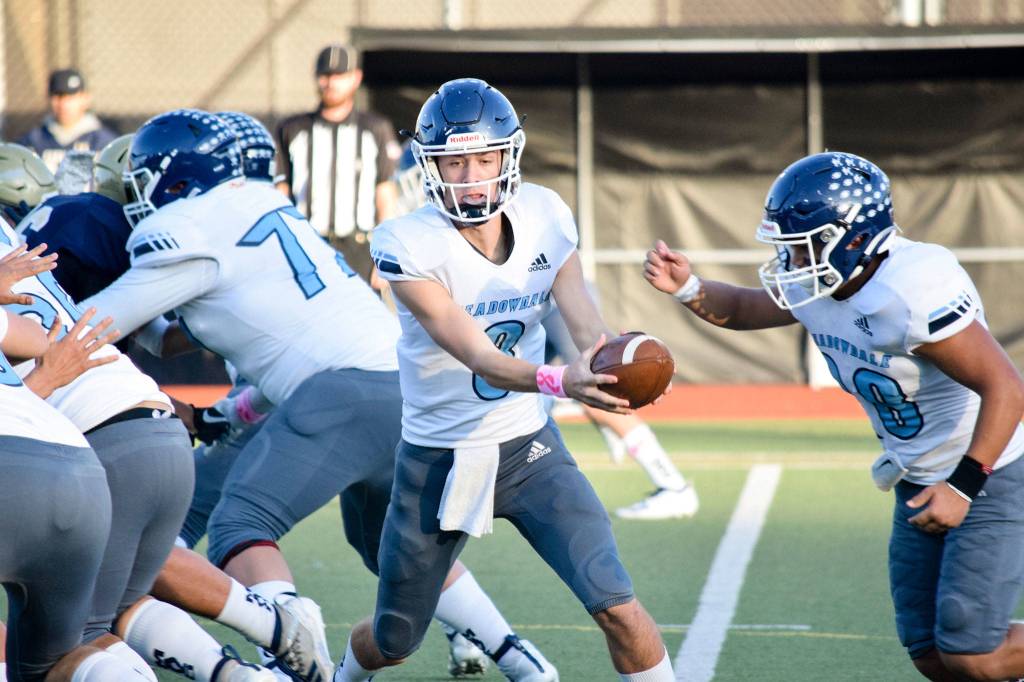Senior quarterback Hunter Moen hands off the ball to senior running back Caleb Monillas against Everett on Friday, Oct. 11 at Everett Memorial Stadium. (Katie Webber / The Herald)