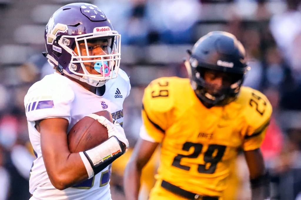 Lake Stevens Kasen Kinchen races to the end zone for a touchdown with Lincolns Amarian Culpepper giving chase Friday night at Lincoln Bowl in Tacoma on September 13, 2019. Lake Stevens won 35-26. (Kevin Clark / The Herald)