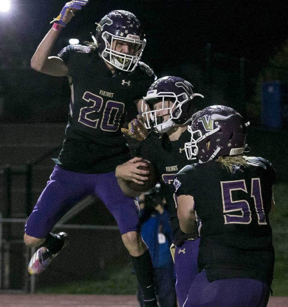 Lake Stevens Joe Gonzales (left) celebrates with Mason Gack (right) Jackson Grafes (center) touchdown Friday night at Lake Stevens High School on October 5, 2018. (Kevin Clark / The Herald)